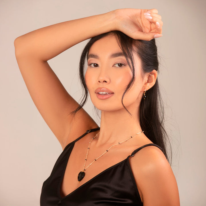 Collana con cuore in onice nero faccettato su catena con pallini neri in acciaio dorato