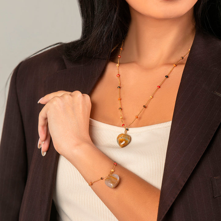 Collana con cuore bombato in agata muschiata su catena con pallini multicolor in acciaio dorato