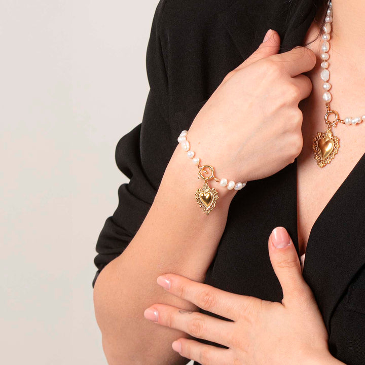 Bracciale nodini in perle di fiume con ex-voto e anello in acciaio dorato